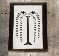 a wooden frame with a black and white tree painted on the front side of it