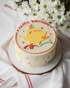 a birthday cake on a plate with flowers in the background