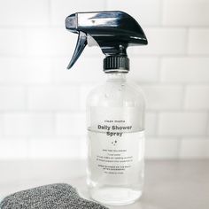 a close up of a bottle of cleaner on a counter with a towel and cloth