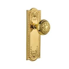 an ornate brass door handle on a white background