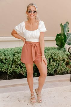 These sweet terracotta shorts are such an amazing choice for any summer afternoon! We love the trendy paperbag high waist fit - you can easily style it with any tops or bodysuits! The tie front and button detail make for a cute combination. Throw these on with a fabulous top and sandals for the perfect casual look! 85% Cotton, 15% linen Machine wash cold / Tumble dry low Unlined Materials may have natural variations Colors may vary from different viewing devices High Waist Shorts Outfits Women, Summer Dressed Up Outfits, Dressy Vacation Outfits Summer, Summer Fit Inspo Women, Breezy Outfits Summer, Womens Cute Summer Outfits, Summer Outfits Photos, Terracotta Shorts Outfit, Shorts With Wedges Outfits