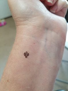 a small cactus tattoo on the wrist