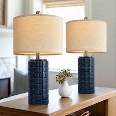 two lamps sitting on top of a wooden table