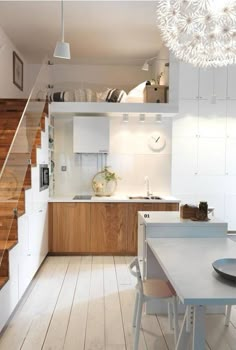 a kitchen with white cabinets and wooden stairs