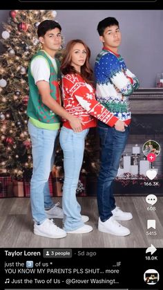 two people standing next to each other in front of a christmas tree