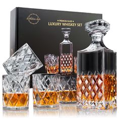 an assortment of whiskey glasses and decanters in front of a black cardboard box