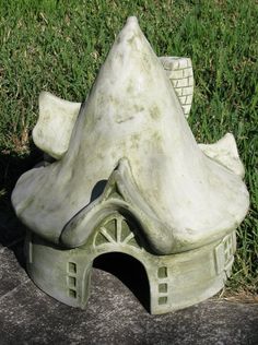 a white sculpture sitting on top of a cement slab