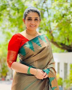 a woman in a sari posing for the camera with her hands on her hips