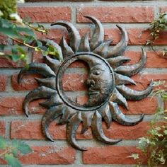 a metal sun and moon on a brick wall