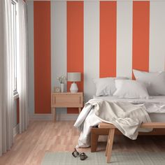 an orange and white striped wall in a bedroom with a bed, nightstands and two lamps