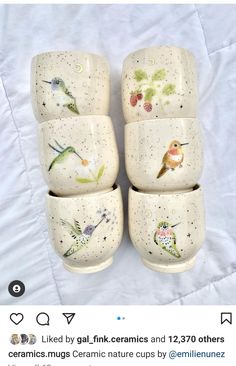 four ceramic cups with birds painted on them are stacked up in the shape of squares