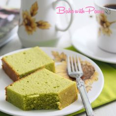 two slices of green tea cake on a plate with a fork and coffee cup in the background