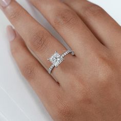 a woman's hand with a diamond ring on top of her finger and an engagement band