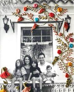 a family is sitting on a window sill with flowers and decorations around the windowsill