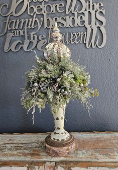 a vase filled with flowers sitting on top of a wooden table next to a wall