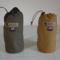 two bags with tags on them sitting next to each other, one has a bottle in it