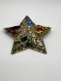 "Nice gold tone metal star with red ,blue ,green, yellow and clear glass rhinestones. LA ROCO star is from 1950-1960's In good  pre-owned vintage condition Measures :2 3/4\" in diameter Not signed Please note that due to lighting effects, monitor's brightness, contrast and other settings, there might be some slight differences in the color tone/shade of the website's photo and the actual item. Item photos are enlarged to show details- please note actual sizes. Please ask any questions. Please se Retro Rhinestone Brooches For Gifts, Gold Star Brooches As Gift, Vintage Star-shaped Jewelry For Party, Vintage Star-shaped Party Jewelry, Star Brooch, Metal Star, Metal Stars, White Peonies, Brooch Vintage