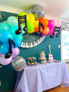 a table with balloons and musical instruments on it