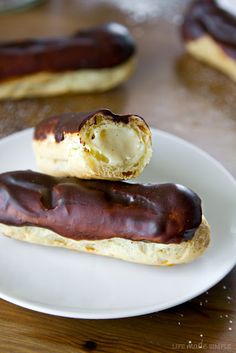 two chocolate covered donuts on a white plate