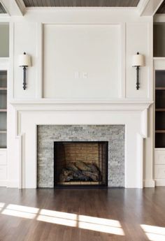 an empty living room with a fireplace and bookcases on either side of the fire place