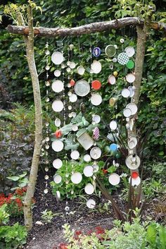 a garden area with plants and plates hanging from the trees