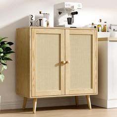 a wooden cabinet sitting next to a potted plant