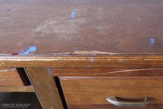 an old wooden desk with peeling paint on the top and bottom part of it's drawers