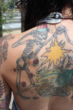 the back of a man with tattoos on his body