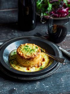 a plate with some food on top of it next to a glass of wine and fork