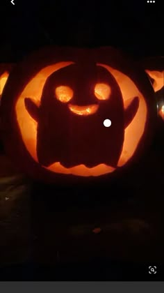 a carved pumpkin with an evil face on it's side and eyes glowing in the dark