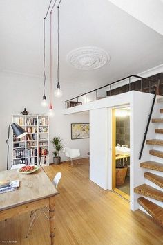 a living room filled with furniture next to a stair case and wooden floored stairs