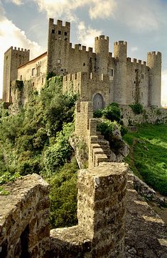 an old castle sits on top of a hill