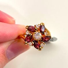 Nwt 14k Gold Electroplated Royal Floral Spring Avantgarde Purple Rhinestone Ring Step Up Your Look With This Bling Ring. Letting Off Lots Of Sparkle With It's Purple Rhinestone Petals Surrounded By Smaller Clearer Rhinestone, All Set In A 14k Gold Electroplated Base. The Perfect Way To Elevate Any Outfit. Nwt, And Contain No Flaws. Tag Says Is It A Size 5. Look Confident, Feel Confident Like What You See? Visit My Page For More Unique Finds! Offers Welcome Gold Ruby Ring With Gemstone Accents For Anniversary, Gold Multi-stone Garnet Jewelry, Gold Garnet Multi-stone Jewelry, Gold Cluster Ruby Ring As Gift, Gold Birthstone Cluster Ring, Gold Cluster Jewelry With Sparkling Stones, Gold Cluster Ring With Birthstone, Cubic Zirconia Ruby Ring With Gemstone Accents For Anniversary, Gold Cluster Ring With Cubic Zirconia Accent Stones