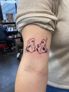 a woman's arm with two dogs tattoo on the left side of her right arm