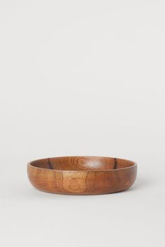 a wooden bowl sitting on top of a white table