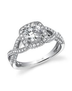 a white gold ring with an oval cut diamond in the center and pave set shoulders