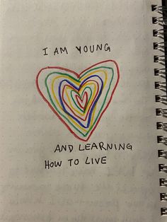 i am young and learning how to live written on a notebook with colored lines in the shape of a heart