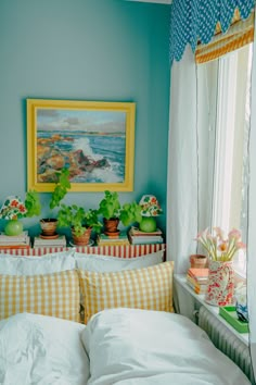 a bed room with a neatly made bed and pictures on the wall above it's headboard