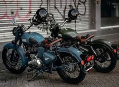 two motorcycles parked next to each other in front of a building with graffiti on it