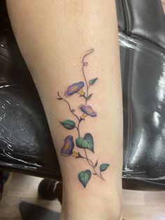 a tattoo on the leg of a woman that has leaves growing out of her legs