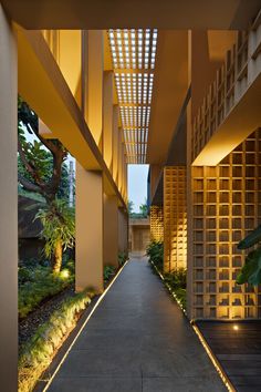 the walkway between two buildings is lit up by lights on either side of the walkway