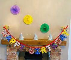 a fireplace with decorations on the mantle for a birthday party