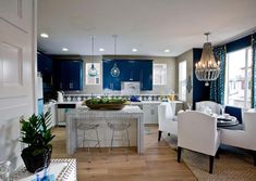 a living room filled with white furniture and blue walls