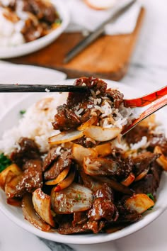 a close up of a plate of food with chopsticks sticking out of it