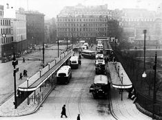 an old black and white photo of buses on the street