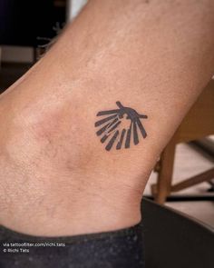 a small tattoo on the foot of a person with an arrow in their hand and four hands