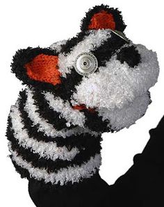 a black and white stuffed animal with an orange eye patch on it's nose