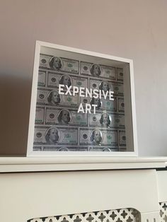 the words expensive art are displayed in front of stacks of money on top of a fireplace mantel