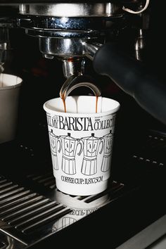 coffee being poured into a paper cup in front of an espresso machine with the words la barista college written on it