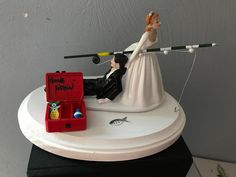 a wedding cake topper with a bride and groom fishing